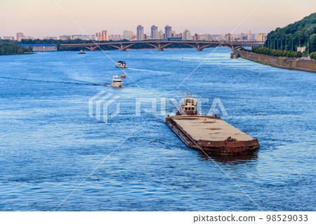 Heavy long barge sailing on the Dnieper river in Kiev, Ukraine 98529033