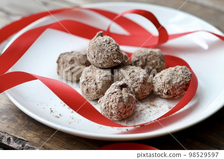 巧克力松露，上面覆蓋著切碎的巧克力和紅色絲帶 98529597