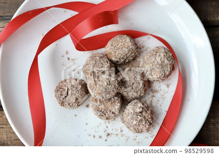 巧克力松露，上面覆蓋著切碎的巧克力和紅色絲帶 98529598