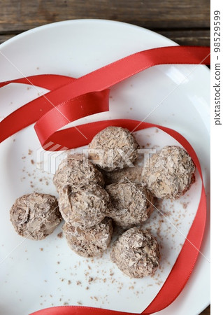 巧克力松露，上面覆蓋著切碎的巧克力和紅色絲帶 98529599