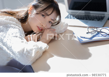 young woman lying down on desk young woman lying down on desk 98530771