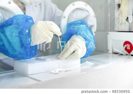 Close up to the rubber gloves on the asian medical staff is processing coronavirus or covid-19 test in the negative room pressure. Close up to the rubber gloves on the asian medical staff is processing coronavirus or covid-19 test in the negative room pressure. 98530950
