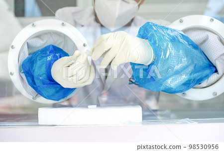 Close up to the rubber gloves on the asian medical staff is processing coronavirus or covid-19 test in the negative room pressure. 98530956