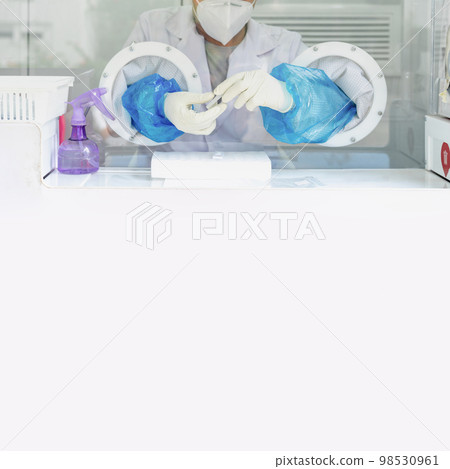 Close up to the rubber gloves on the asian medical staff is processing coronavirus or covid-19 test in the negative room pressure. Close up to the rubber gloves on the asian medical staff is processing coronavirus or covid-19 test in the negative room pressure. 98530961
