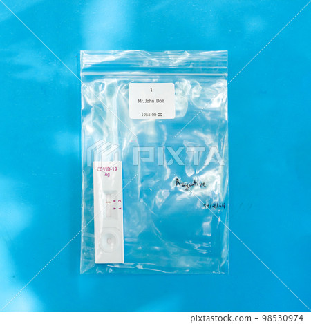 The Coronavirus (COVID-19) test result in the zip bag on blue background. The Coronavirus (COVID-19) test result in the zip bag on blue background. 98530974