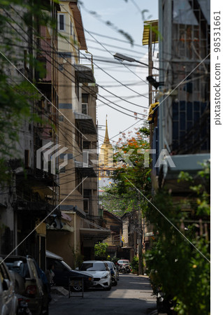 Focus on the Golden Mountain, Thailand ancient temple and landmark behind the local home building with unkempt cable all around. Focus on the Golden Mountain, Thailand ancient temple and landmark behind the local home building with unkempt cable all around. 98531661