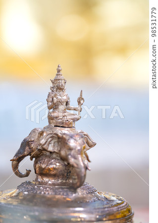 Deity of God Indra is riding Erawan (Airavata) three head elephant, the Bronze Statue on yellow and pastel shade background. 98531779