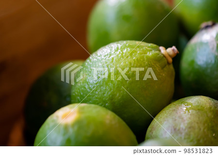 close up fresh lime, lemone in studio light on black stone plate in the kitchen. 98531823