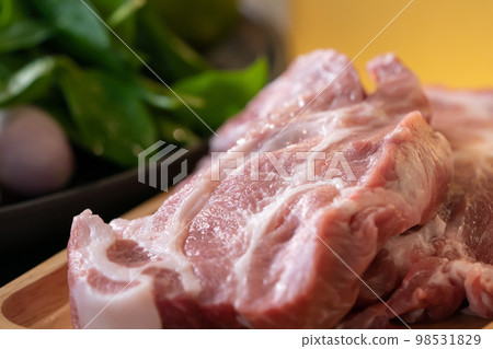 Close up macro shooting sliced pork meat on wood plate in studio light. Close up macro shooting sliced pork meat on wood plate in studio light. 98531829