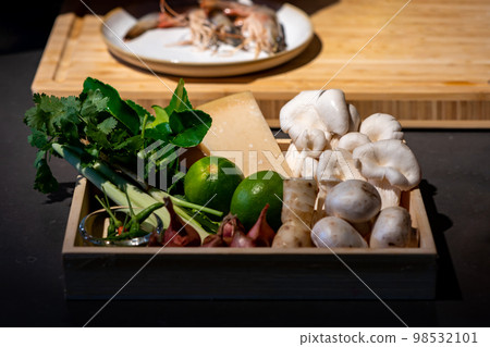 Cooking ingredient, lime, mushroom, shallot, lemon grass, spring onion, chilli, bergamot leaves and cheese in wood box plate. They are ready for meal cooking. 98532101