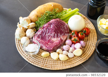 close up to Raw Ingredients for beef steak and mushroom sauce menu on circle wicker plate. close up to Raw Ingredients for beef steak and mushroom sauce menu on circle wicker plate. 98532120