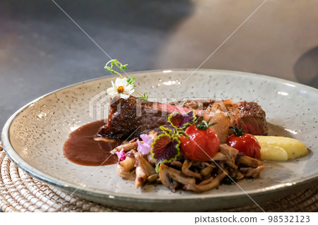 Medium Rare Beef Steak and fried sliced mushroom are decorated by little flower on white dish, ready to serve and eat. Medium Rare Beef Steak and fried sliced mushroom are decorated by little flower on white dish, ready to serve and eat. 98532123