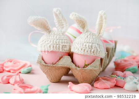 Happy Easter holiday concept with cute handmade eggs, knitted bunny hats and sweet pink decor, copy space. Greeting card, banner for your site, flyer, banner, invitation, discount card 98532219