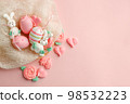 Pastel colored Easter eggs in nest, sweet tender decor from funny meringue and on pink background. Traditional springtime holiday greeting card, invitation, banner, Top view. Copy space 98532223