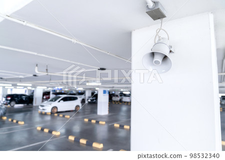 A Megaphone speaker is set up on the pole ceilling in car parking area. A Megaphone speaker is set up on the pole ceilling in car parking area. 98532340