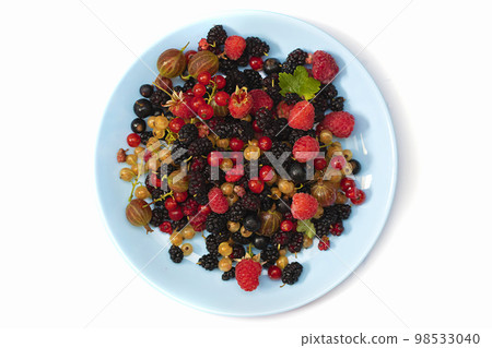 On a white background a plate with summer berries. Fruit salad with raspberries, gooseberries, currants, mulberries. Flat lay, top view On a white background a plate with summer berries. Fruit salad with raspberries, gooseberries, currants, mulberries. Flat lay, top view 98533040