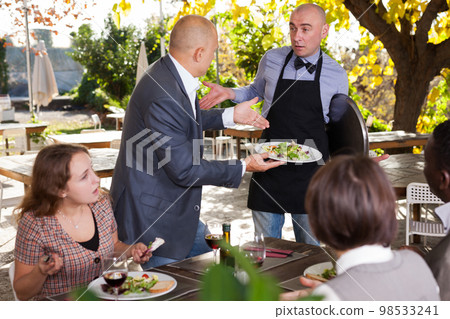 Restaurant guests complain about the food to the waiter Restaurant guests complain about the food to the waiter 98533241