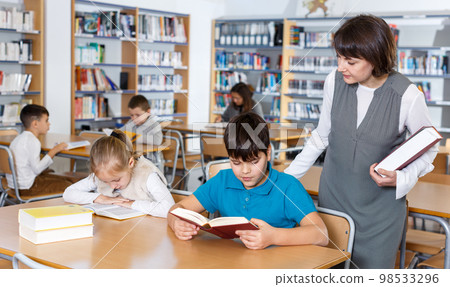 School kids studying with female teacher 98533296