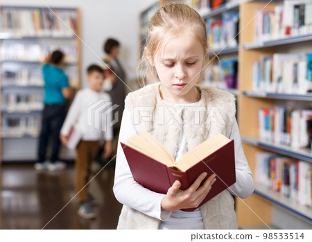 Preteen girl browsing textbook 98533514