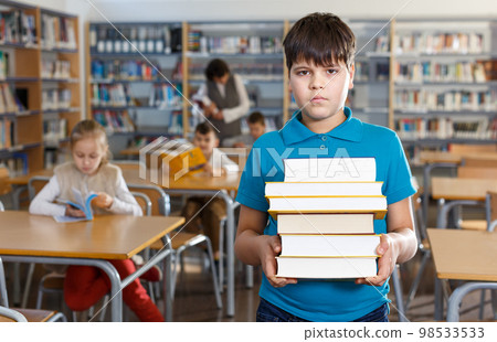 Upset boy standing with books Upset boy standing with books 98533533
