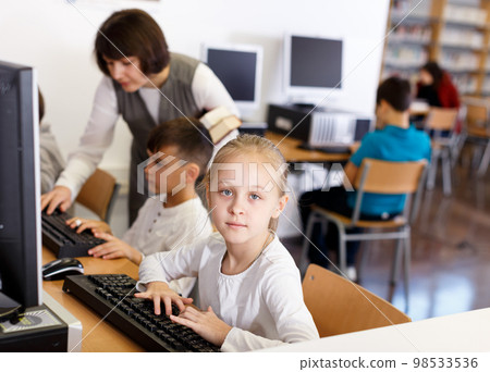 Preteen girl studying in computer class Preteen girl studying in computer class 98533536