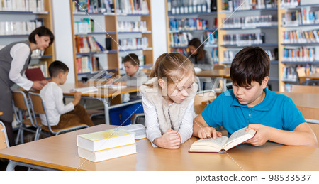 School friends reading books in library School friends reading books in library 98533537
