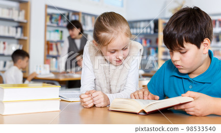 Two school children reading in school library Two school children reading in school library 98533540