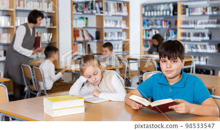 Girl and boy studying in school library Girl and boy studying in school library 98533547