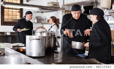 Chef male dissatisfied with the work of girl helper Chef male dissatisfied with the work of girl helper 98533563