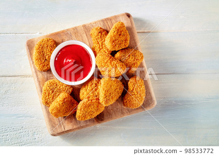 Chicken nuggets with bbq sauce on a rustic wooden background, top shot Chicken nuggets with bbq sauce on a rustic wooden background, top shot 98533772