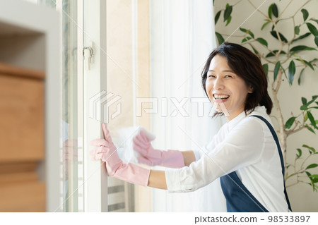 middle woman cleaning windows 98533897