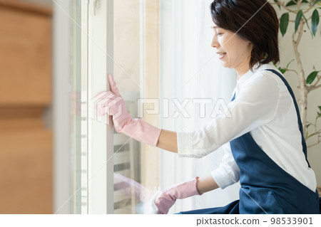 middle woman cleaning windows middle woman cleaning windows 98533901