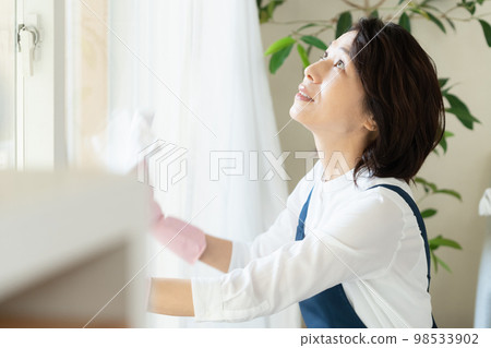 middle woman cleaning windows middle woman cleaning windows 98533902
