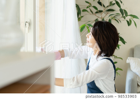 middle woman cleaning windows middle woman cleaning windows 98533903