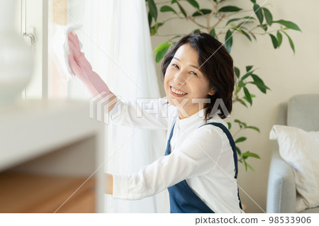 middle woman cleaning windows middle woman cleaning windows 98533906
