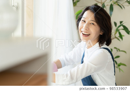 middle woman cleaning windows middle woman cleaning windows 98533907