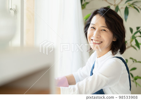 middle woman cleaning windows middle woman cleaning windows 98533908