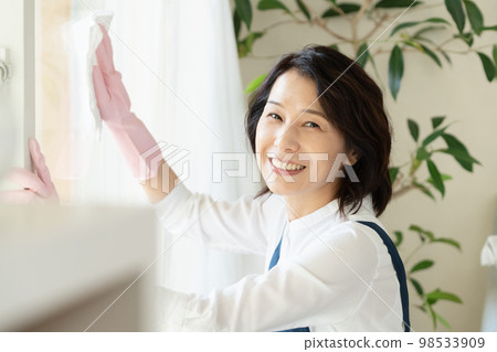 middle woman cleaning windows middle woman cleaning windows 98533909