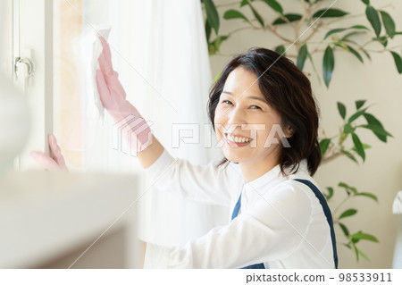 middle woman cleaning windows middle woman cleaning windows 98533911