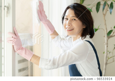 middle woman cleaning windows middle woman cleaning windows 98533914