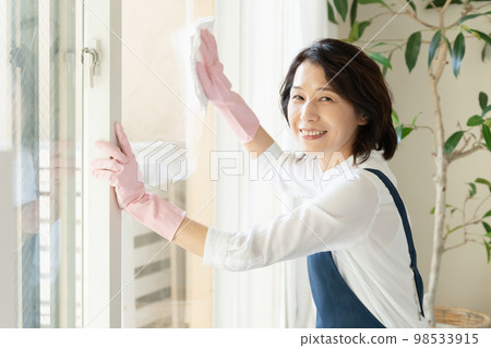 middle woman cleaning windows middle woman cleaning windows 98533915
