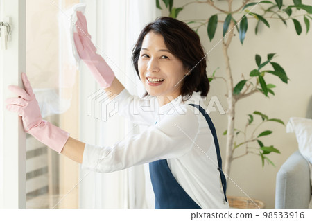 middle woman cleaning windows middle woman cleaning windows 98533916