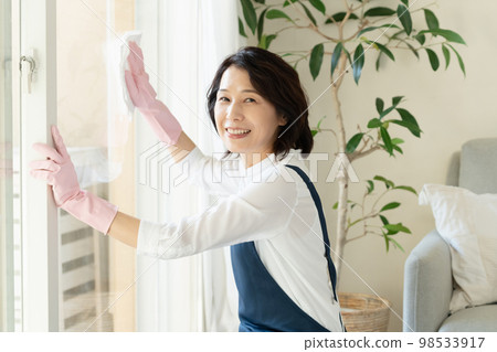 middle woman cleaning windows middle woman cleaning windows 98533917