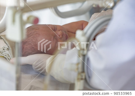 A newborn baby lies in boxes in the hospital. A child in an incubator. Neonatal and Premature Intensive Care Unit 98533965