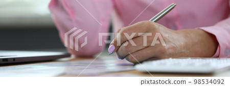 Online education woman analyzes data on sample graphs and writes answers in notebooks 98534092