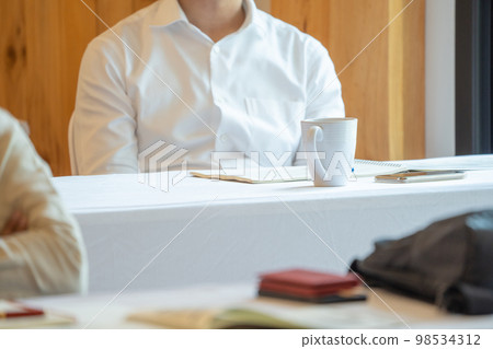 close up to seminar audience with their glass and gadget on the table. 98534312