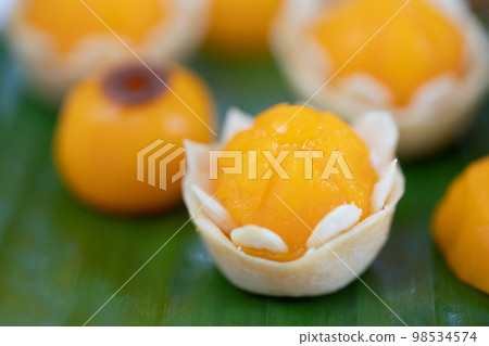 Traditional Golden Thai Dessert; JaMongKut, ThongAek are set on banana leaf. 98534574