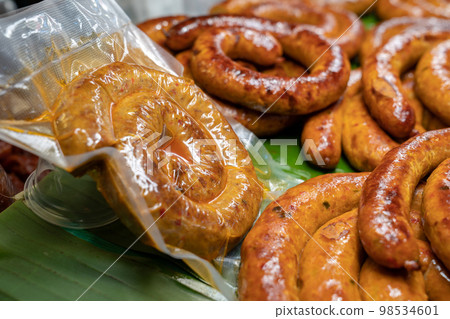 Wrapped packaging of Sai Aua, Northern Thailand Spicy Sausage, a famous Traditional Local saurage cooked with curry and herb at shop and ready for sales. Wrapped packaging of Sai Aua, Northern Thailand Spicy Sausage, a famous Traditional Local saurage cooked with curry and herb at shop and ready for sales. 98534601