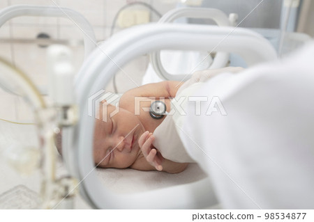 A newborn baby lies in boxes in the hospital. A child in an incubator. Neonatal and Premature Intensive Care Unit A newborn baby lies in boxes in the hospital. A child in an incubator. Neonatal and Premature Intensive Care Unit 98534877