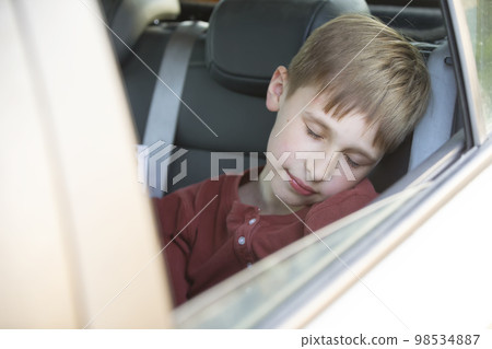 The child sleeps in the car. The little boy was tired and fell asleep in the car. The child sleeps in the car. The little boy was tired and fell asleep in the car. 98534887